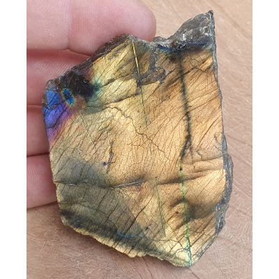 Tranche de labradorite polie et brute derrière